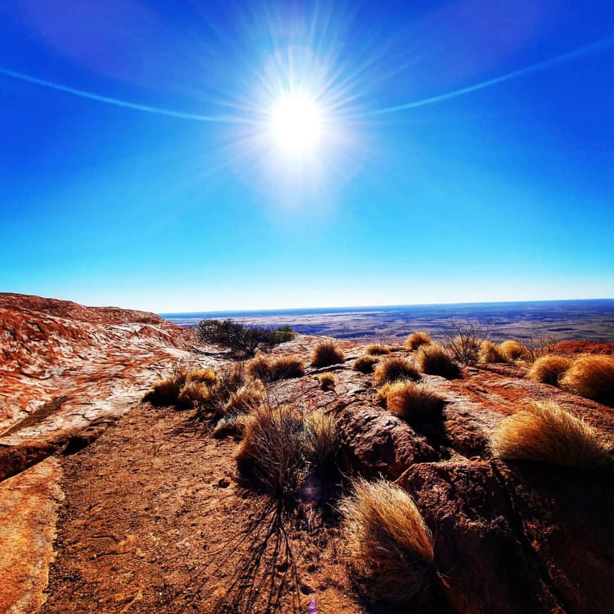 uluru rock formation under bright sun