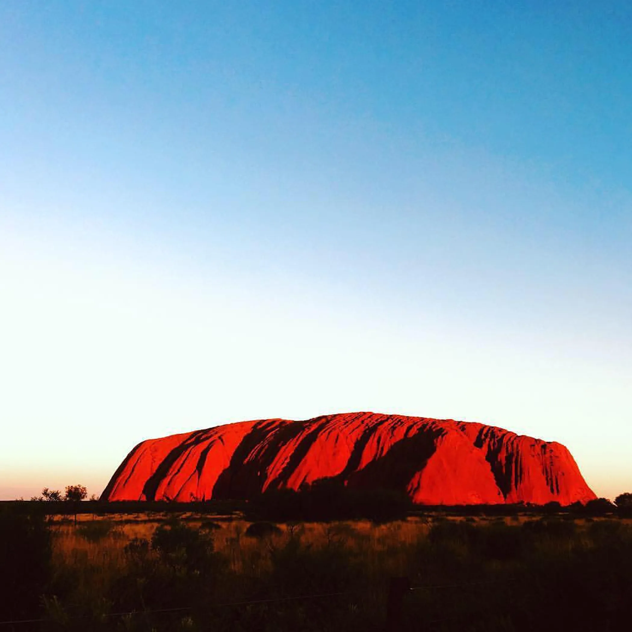 uluru rock formation under clear sky